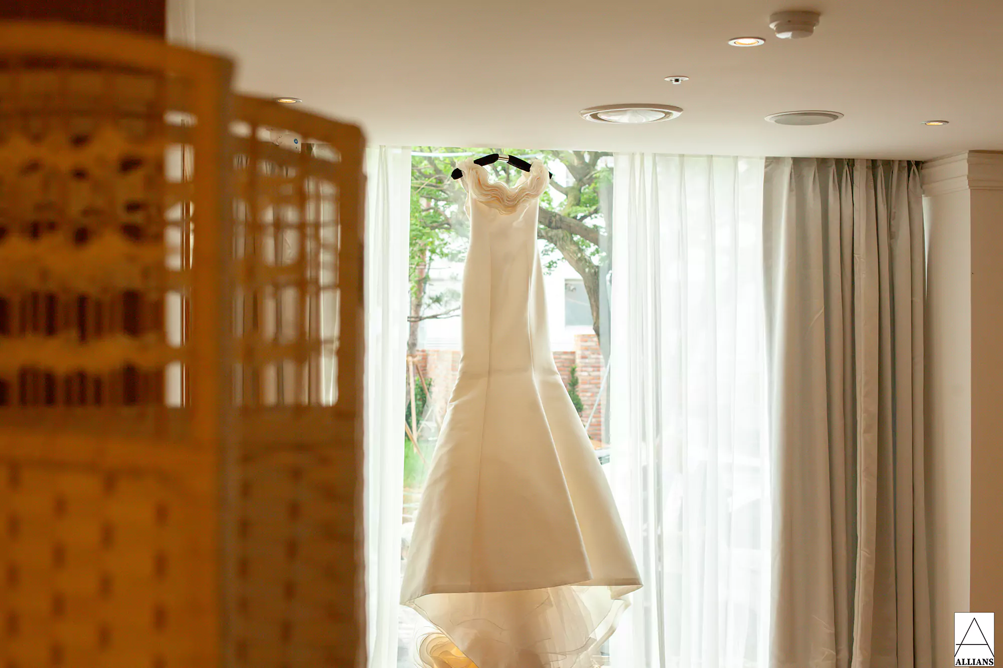 웨딩드레스가 햇살좋은 창에 걸려있는 모습